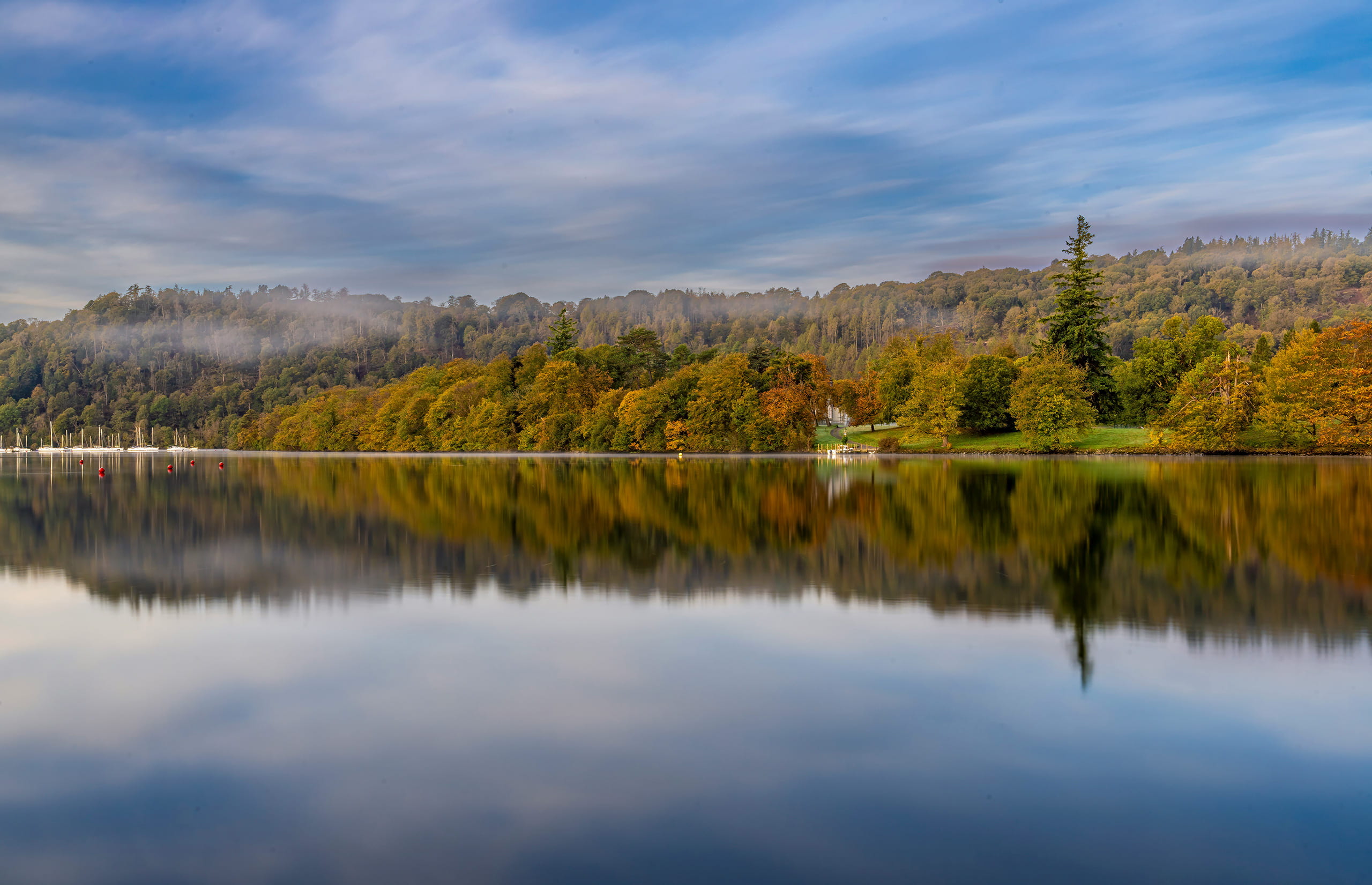 A body of water surrounded by trees during autumn