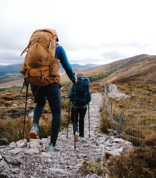 man and women hiking down mountain